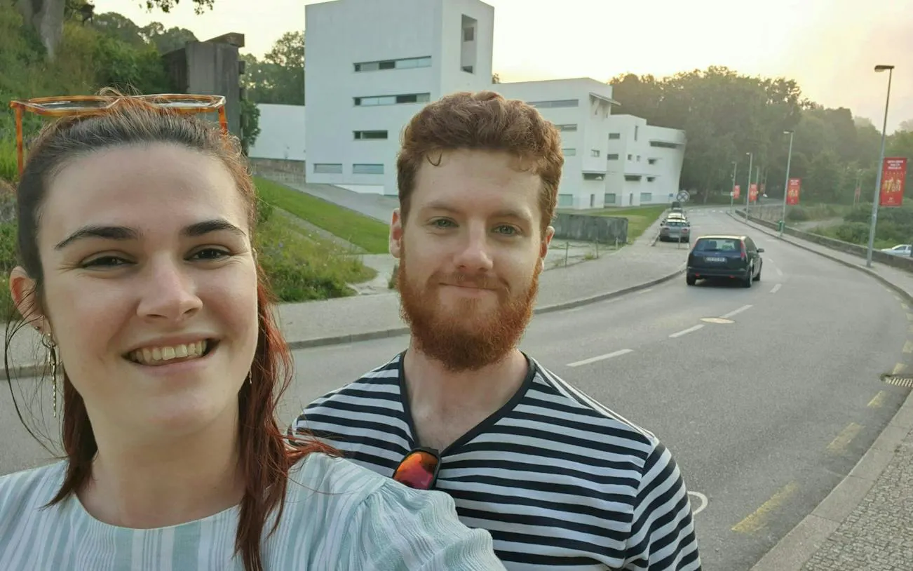 Couple exploring Porto street near modern architecture during self-guided city game.