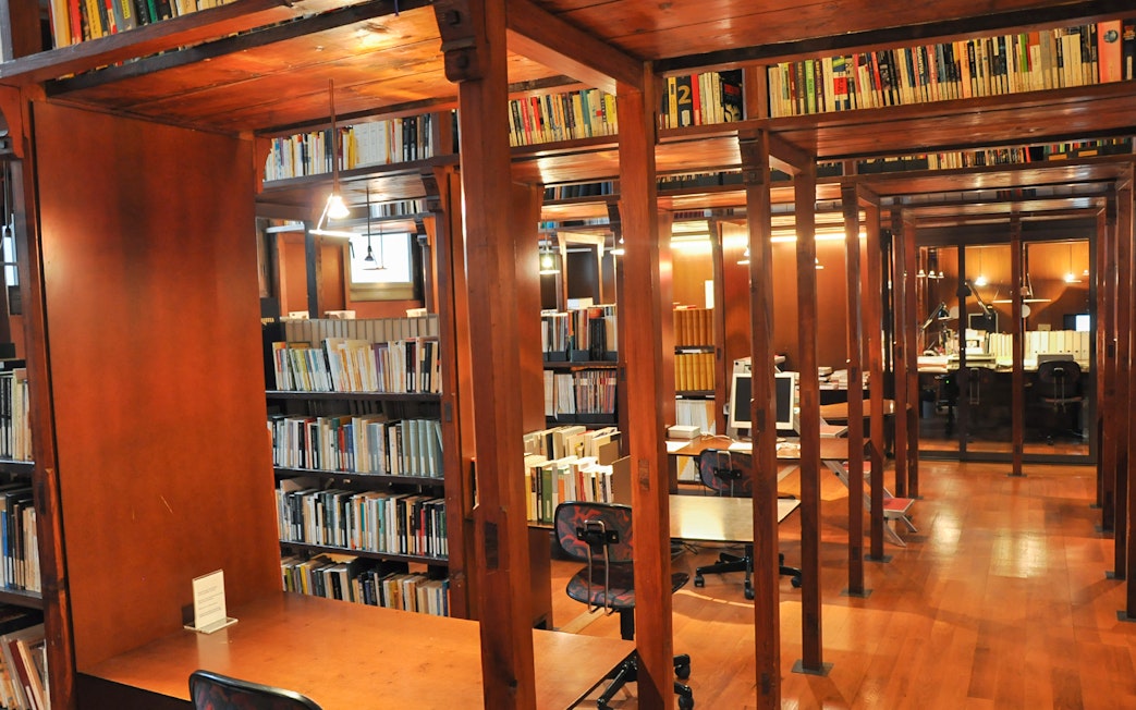 Library interior at Fundació Antoni Tàpies, Barcelona, with wooden shelves and reading desks.