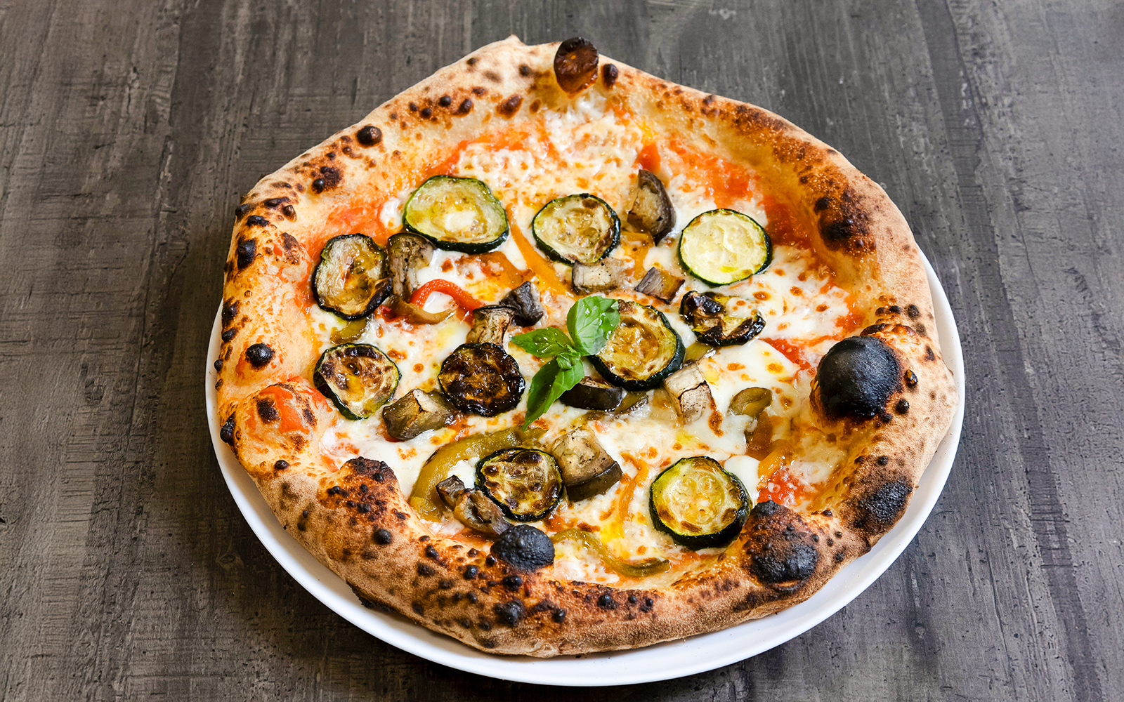 Vegetarian pizza topped with grilled zucchini, eggplant, and peppers.