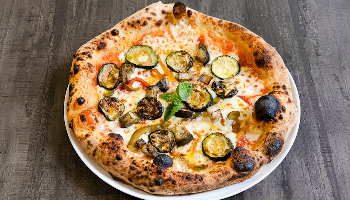 Vegetarian pizza topped with grilled zucchini, eggplant, and peppers.