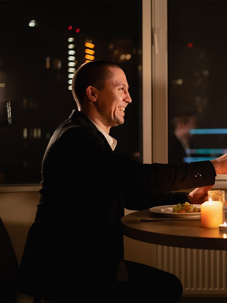 Couple toasting wine glasses during candlelight dinner on Budapest Danube River cruise.