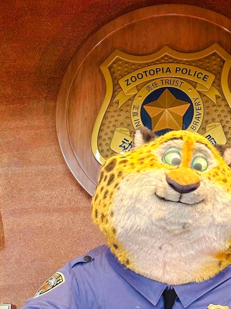 Zootopia police officer character in front of police badge emblem.