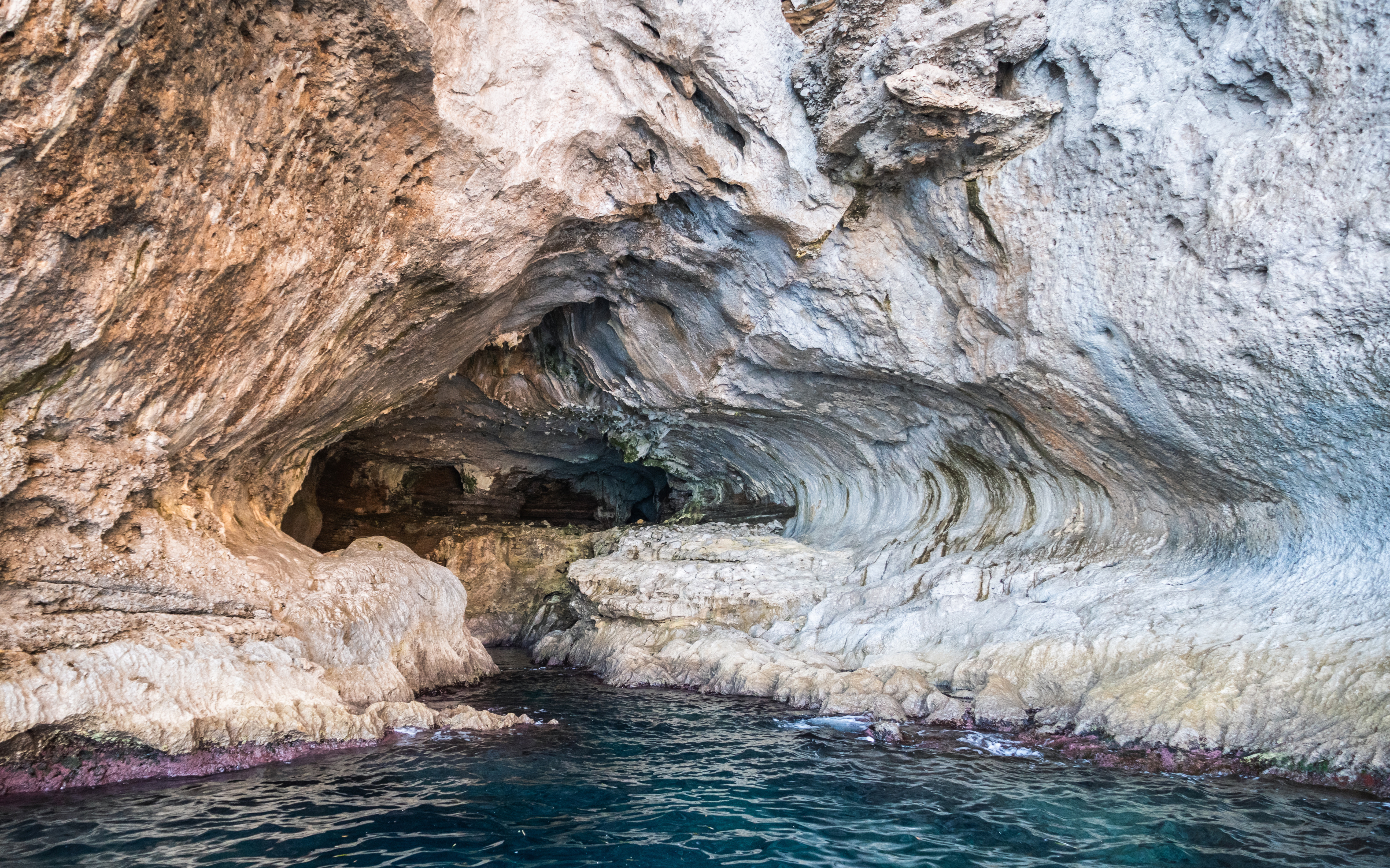 White Grotto cave entrance with rocky formations and blue water, Capri, Italy.
