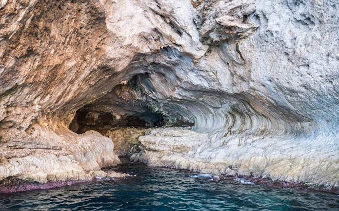 White Grotto cave entrance with rocky formations and blue water, Capri, Italy.