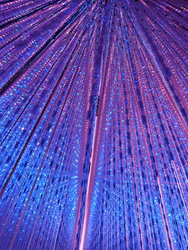 Interactive light installation at TeamLab Planets Tokyo with vibrant blue and purple lights.