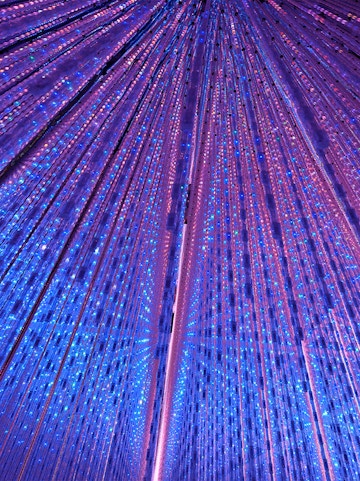Interactive light installation at TeamLab Planets Tokyo with vibrant blue and purple lights.