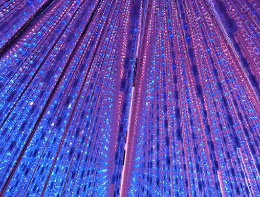 Interactive light installation at TeamLab Planets Tokyo with vibrant blue and purple lights.