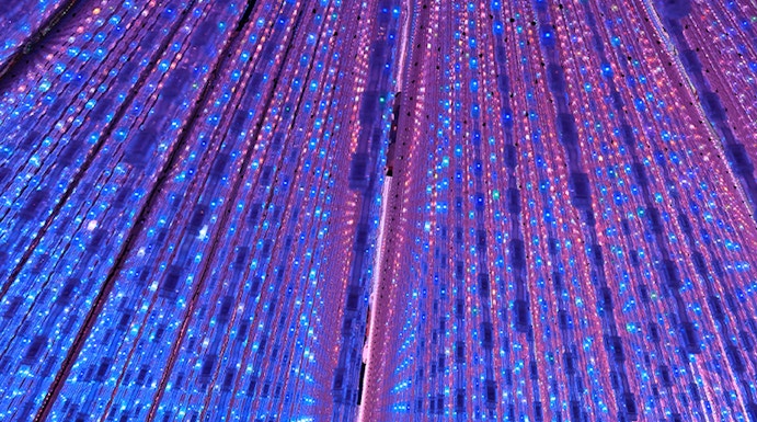 Interactive light installation at TeamLab Planets Tokyo with vibrant blue and purple lights.