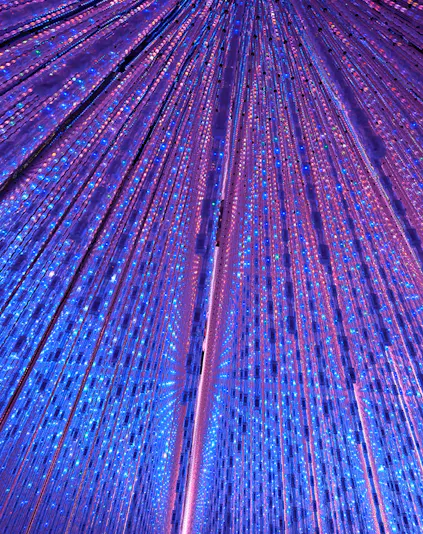 Interactive light installation at TeamLab Planets Tokyo with vibrant blue and purple lights.