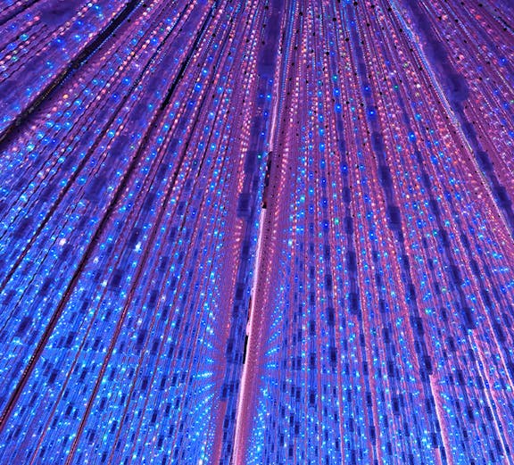 Interactive light installation at TeamLab Planets Tokyo with vibrant blue and purple lights.