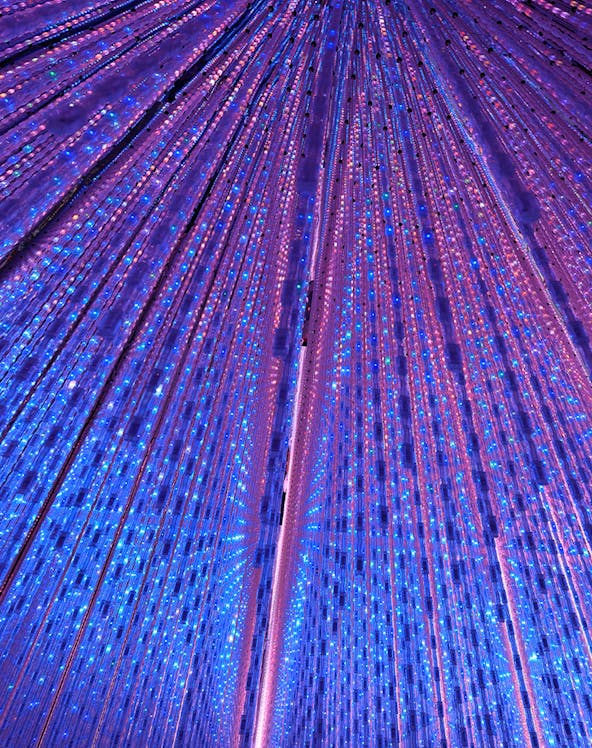 Interactive light installation at TeamLab Planets Tokyo with vibrant blue and purple lights.