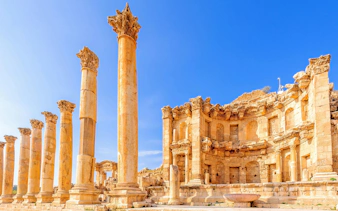 Nymphaeum ruins with columns in Jerash, Jordan under clear blue sky.
