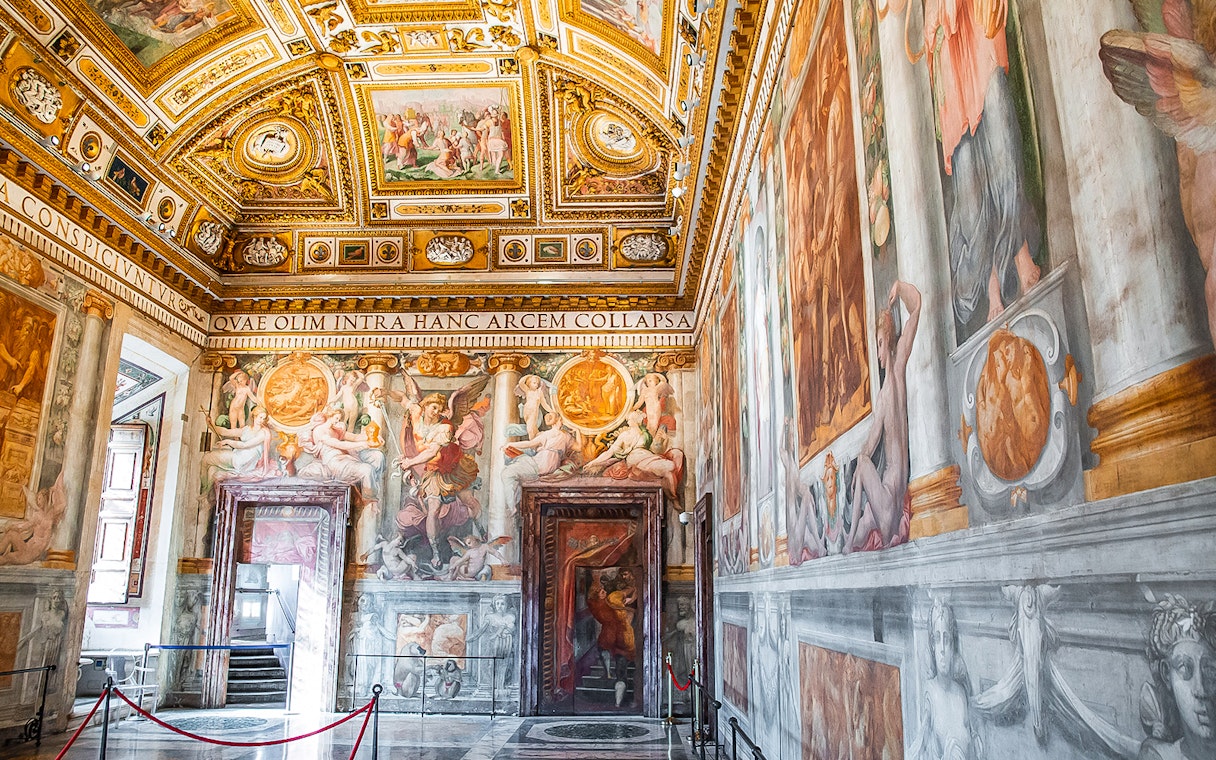 Vatican Museums ornate frescoed room with detailed ceiling and wall art.