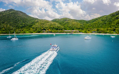 Boat approaching Fitzroy Island with lush hills and clear blue water.