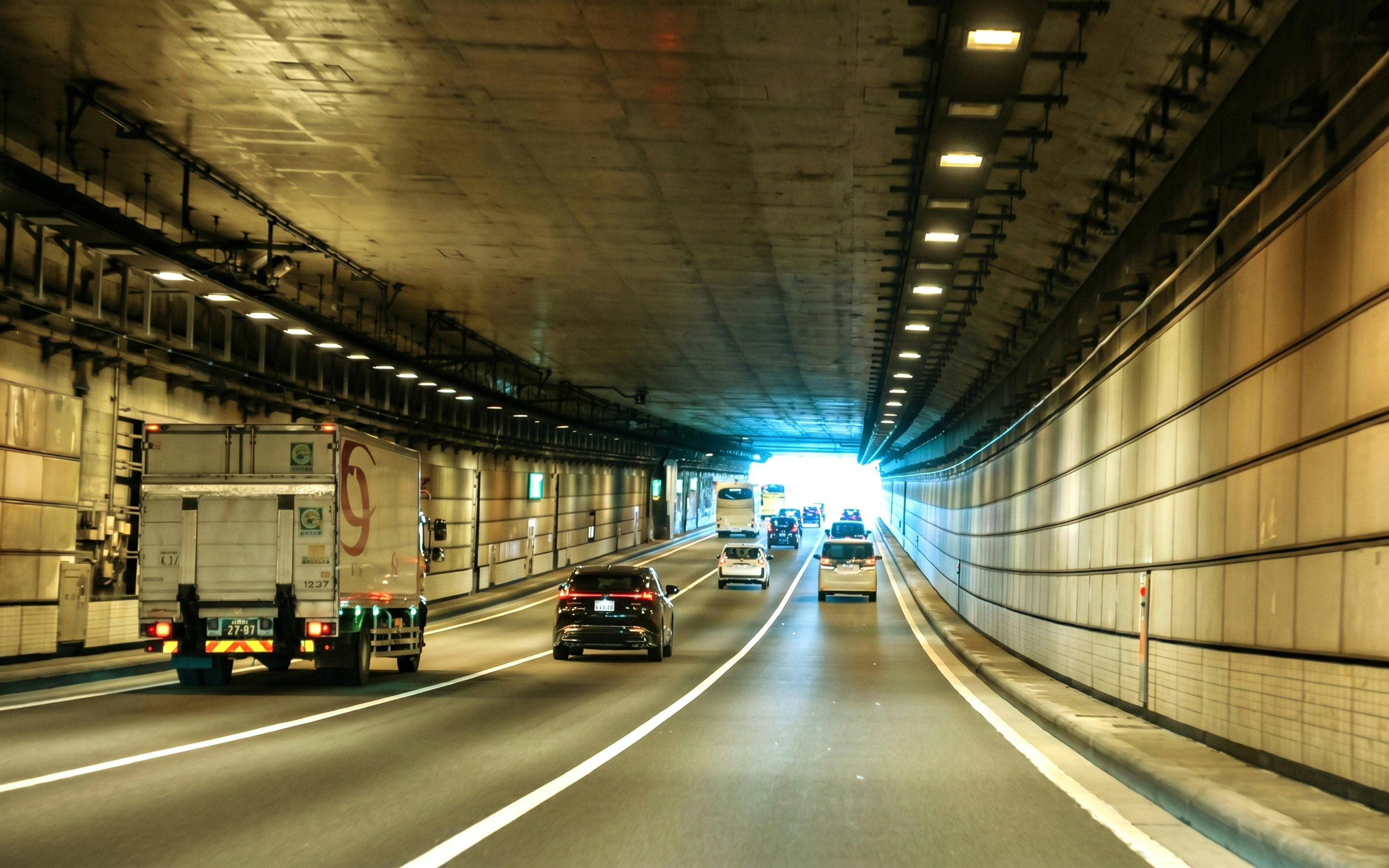 Cars driving through a tunnel in Tokyo, Japan, heading towards Daikoku PA.