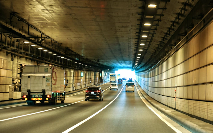 Cars driving through a tunnel in Tokyo, Japan, heading towards Daikoku PA.