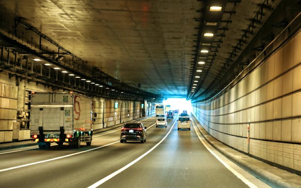 Cars driving through a tunnel in Tokyo, Japan, heading towards Daikoku PA.