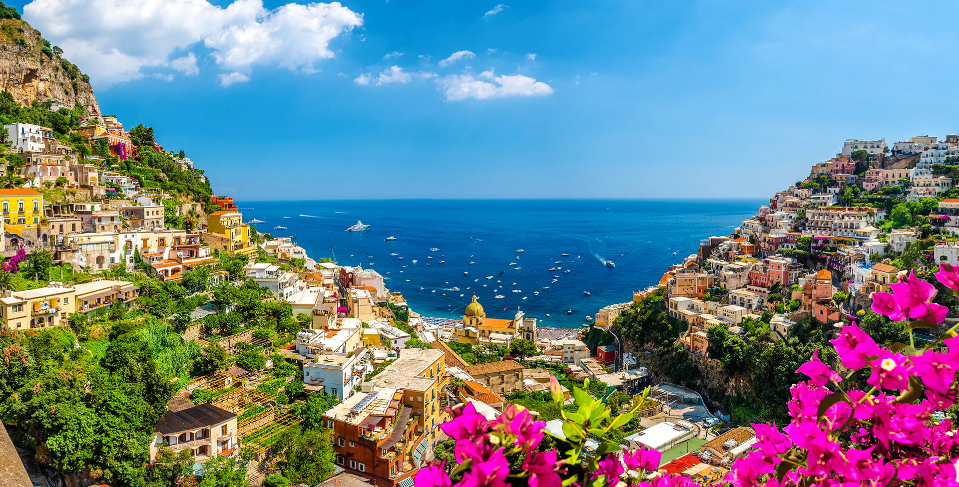 Positano hillside view with colorful buildings and boats on the Amalfi Coast, Italy.