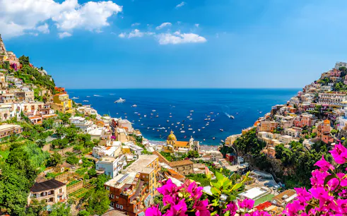 Positano hillside view with colorful buildings and boats on the Amalfi Coast, Italy.