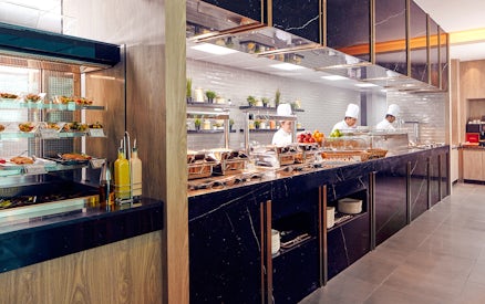 Chefs preparing food at Plaza Premium Lounge, Dubai International Airport.