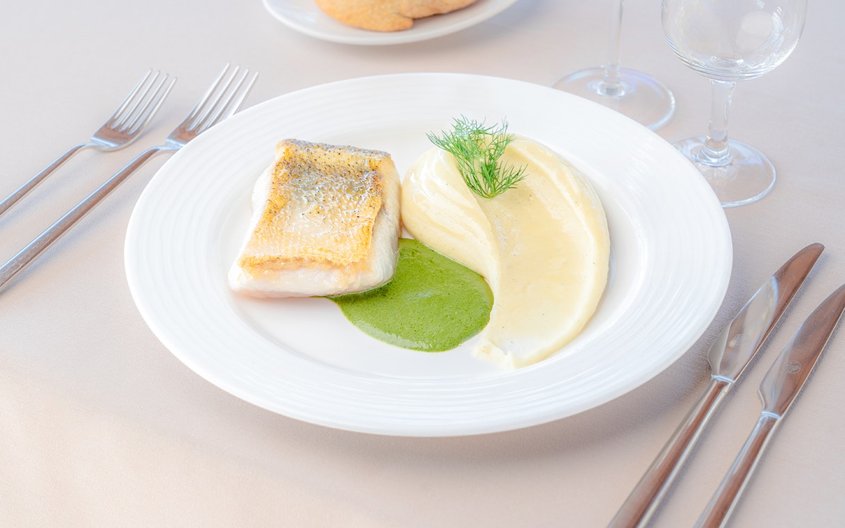 Grilled fish with mashed potatoes and green sauce served on a Seine River sightseeing cruise.