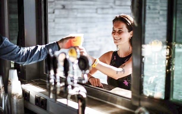 Guests receiving drinks at Geosea Geothermal Baths bar.