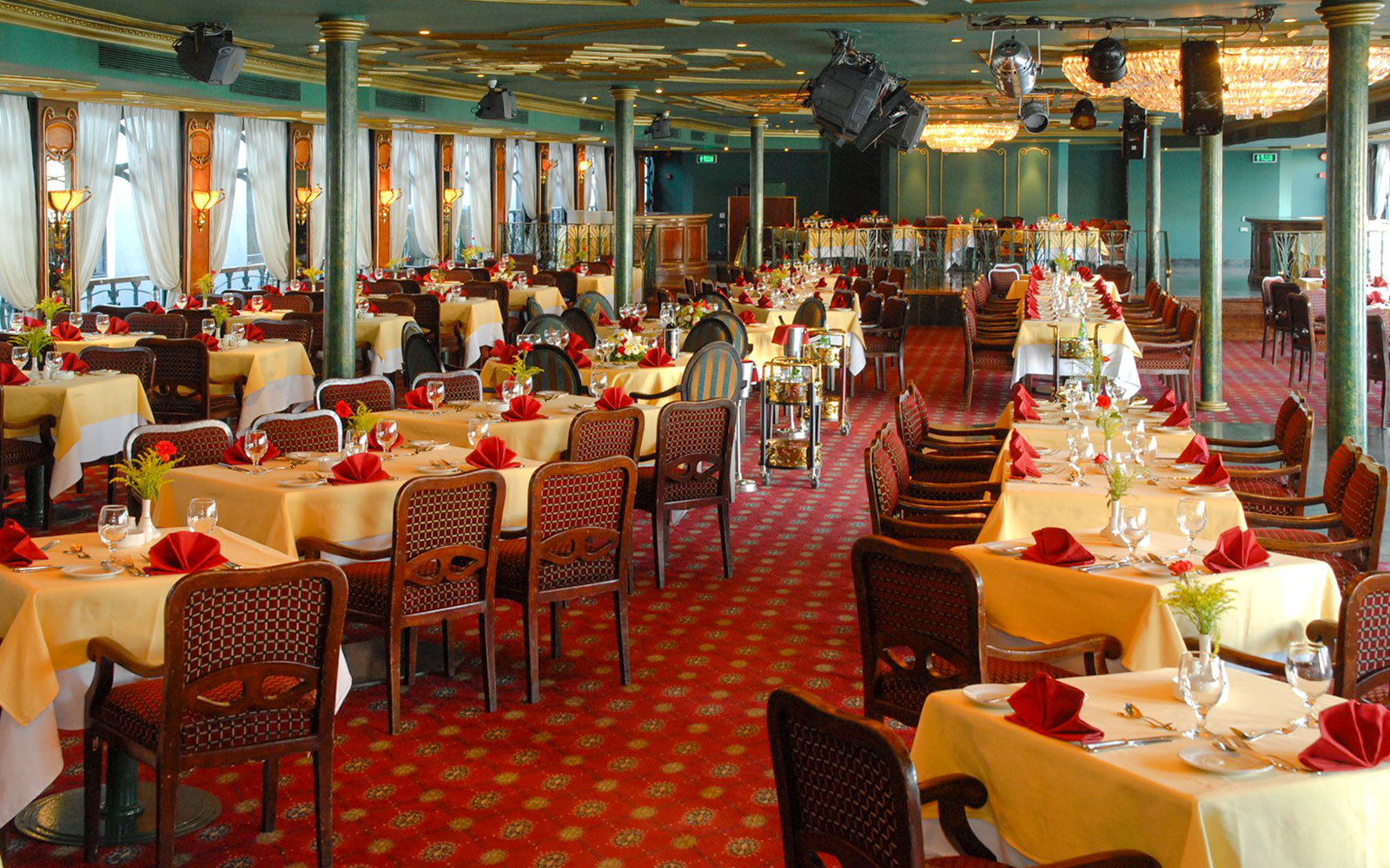Luxury Nile Dinner Cruise dining area with elegantly set tables and red accents.