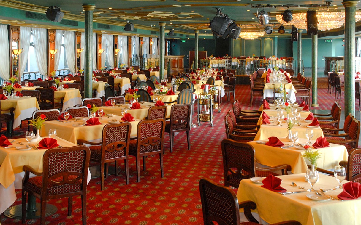 Luxury Nile Dinner Cruise dining area with elegantly set tables and red accents.
