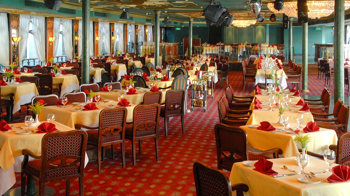 Luxury Nile Dinner Cruise dining area with elegantly set tables and red accents.