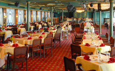 Luxury Nile Dinner Cruise dining area with elegantly set tables and red accents.