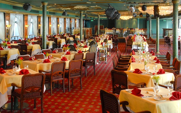 Luxury Nile Dinner Cruise dining area with elegantly set tables and red accents.