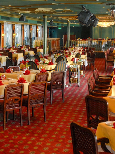 Luxury Nile Dinner Cruise dining area with elegantly set tables and red accents.