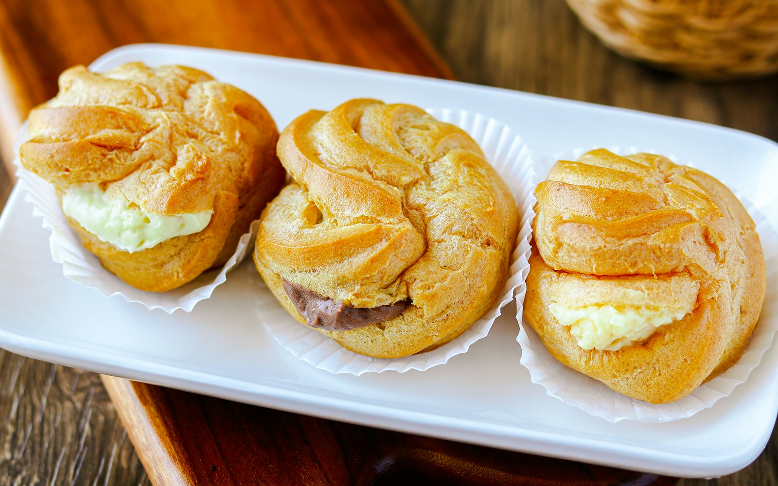 Durian puff pastries on a white plate, showcasing creamy fillings.