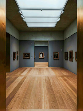 Kunsthaus Zürich museum gallery with wooden floors and framed artworks on gray walls.