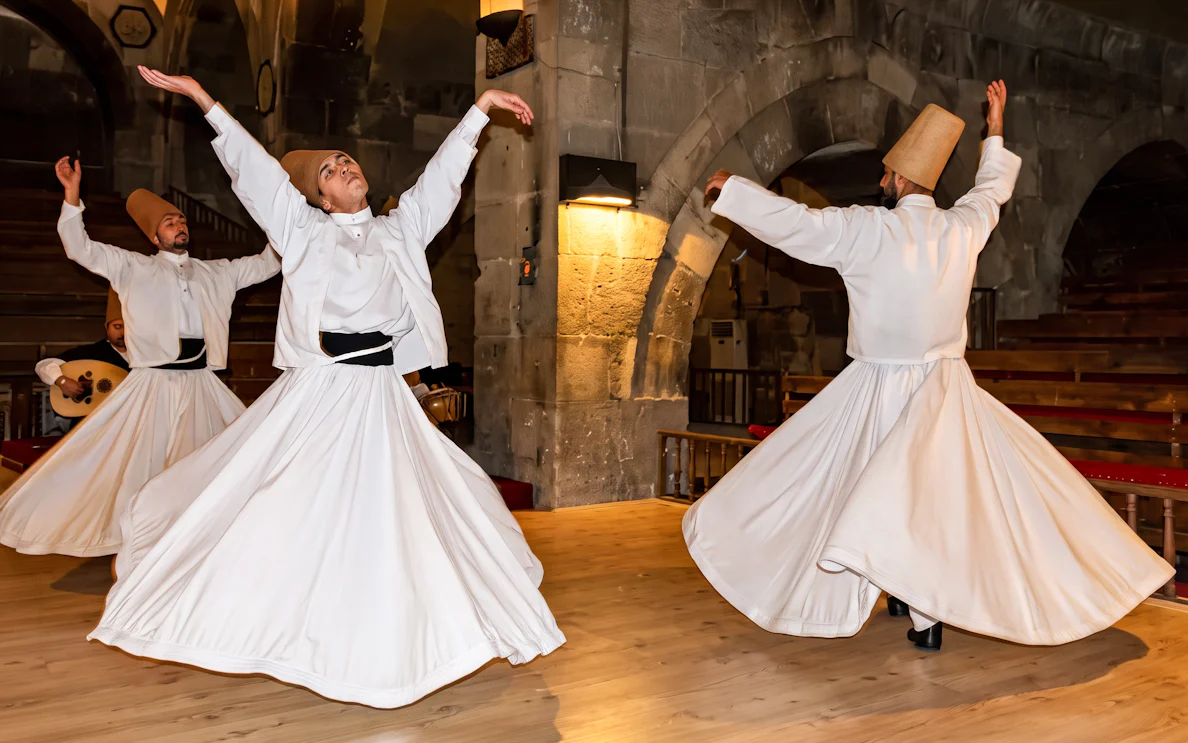 Whirling dervishes performing in a traditional ceremony in Cappadocia, Turkey.