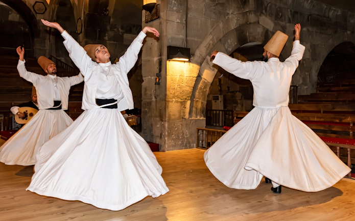 Whirling dervishes performing in a traditional ceremony in Cappadocia, Turkey.