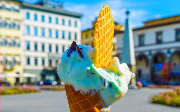 Gelato ice cream cone with wafer in a European city square.