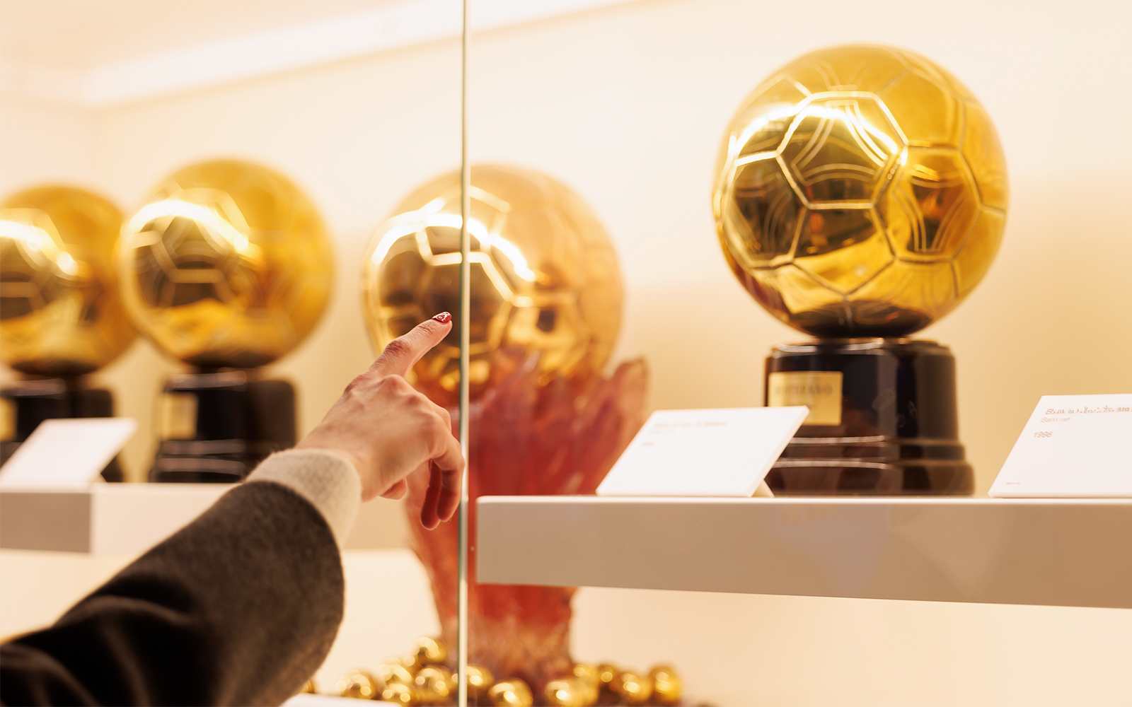 Golden football trophies on display at Santiago Bernabéu Stadium museum.