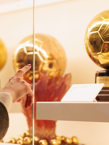 Golden football trophies on display at Santiago Bernabéu Stadium museum.