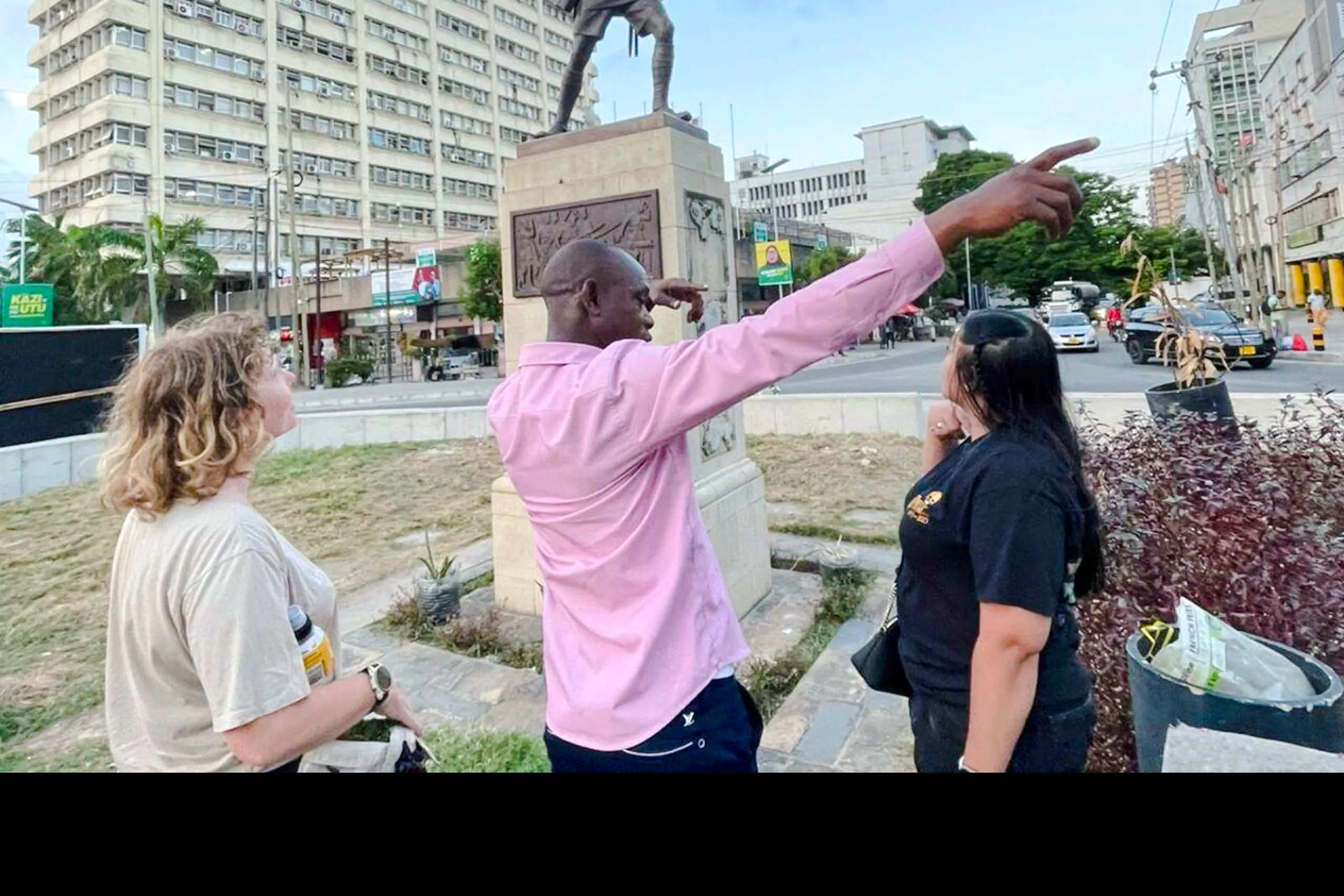Local guide leading a walking tour in Dar es Salaam Old Town, pointing out historical landmarks.