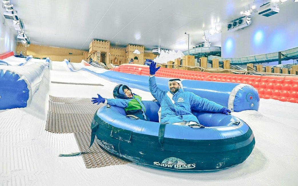 Visitors enjoying a snow tubing ride at Snow Dunes Theme Park.