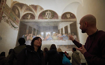 Visitors viewing The Last Supper mural in Milan museum.