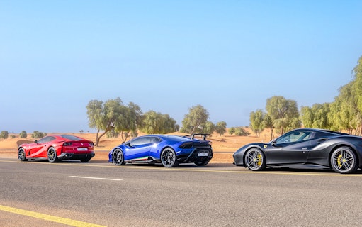 Supercars on a desert road during a self-drive tour in Dubai.