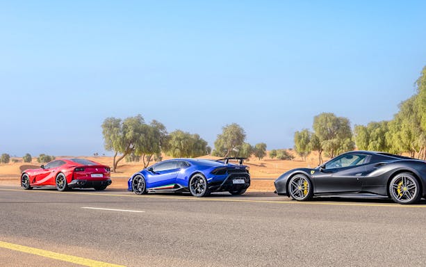 Supercars on a desert road during a self-drive tour in Dubai.