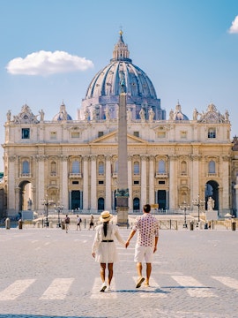 Couple walking towards St. Peter's Basilica in Vatican City.