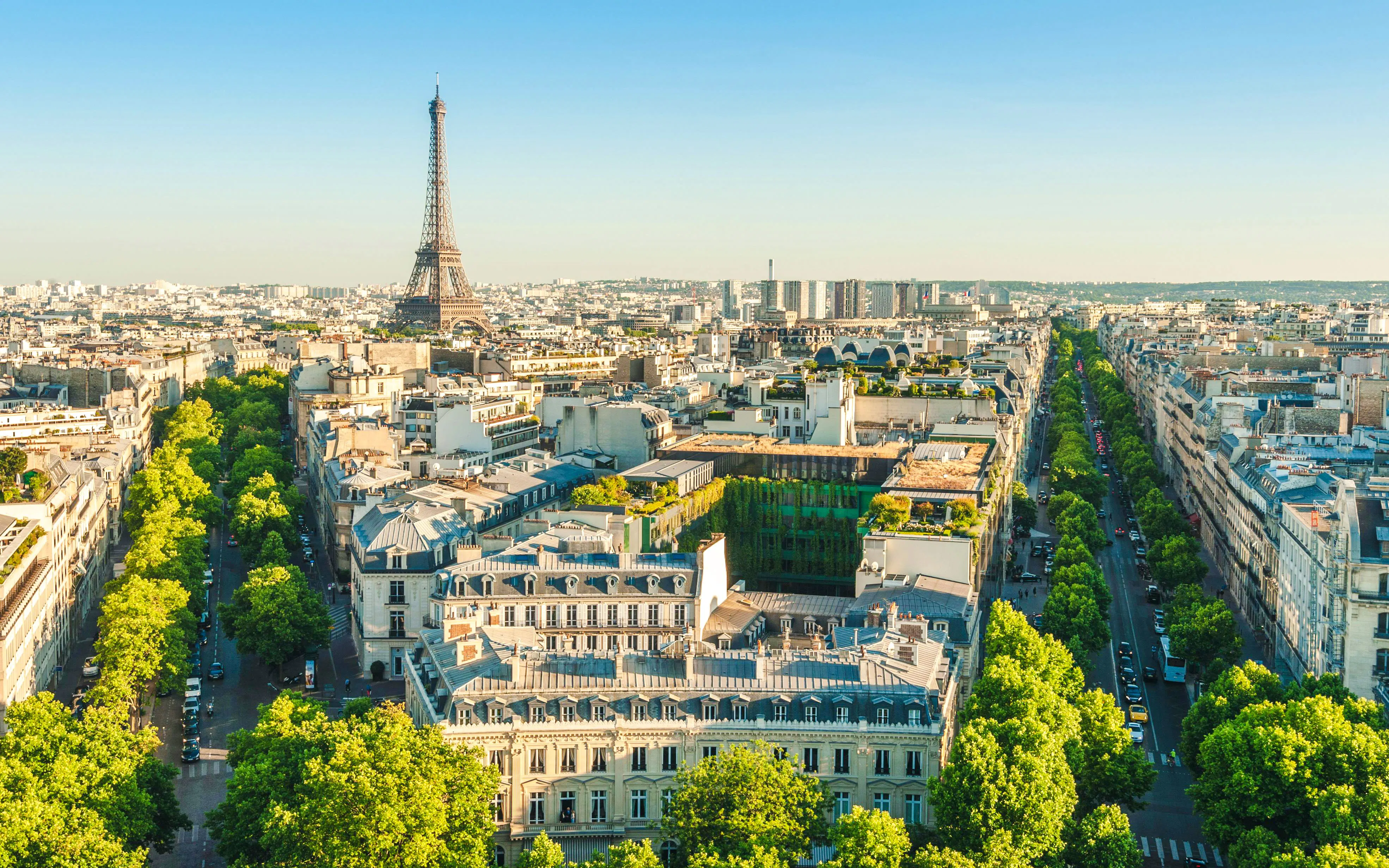 Skyline of Paris with Eiffel Tower at dusk, view over city rooftops.