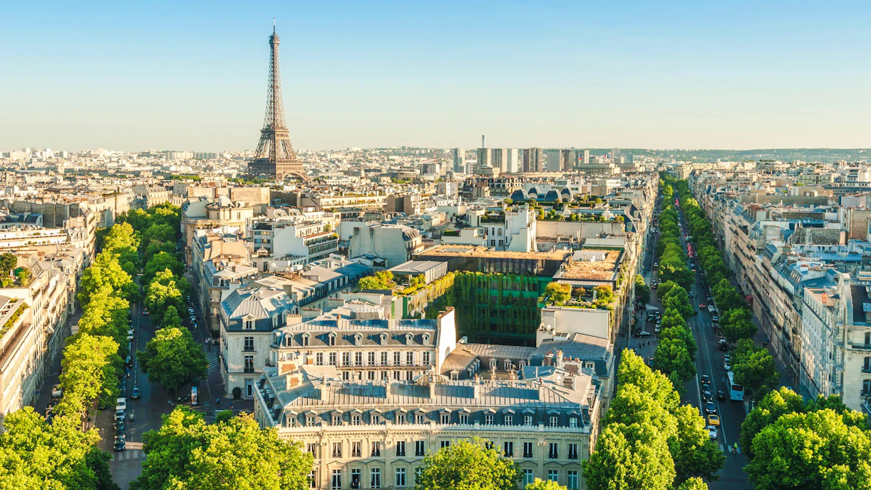 Skyline of Paris with Eiffel Tower at dusk, view over city rooftops.