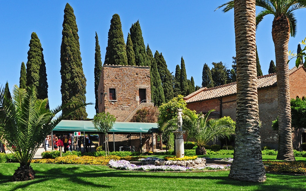 Entrance to Catacombs of St Callixtus with garden and stone building in Rome.