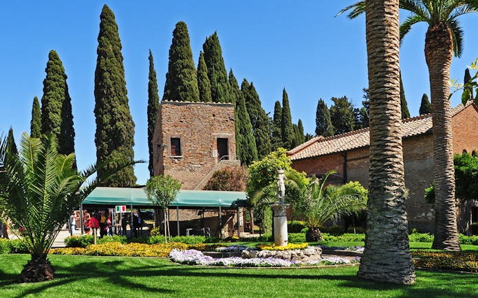 Entrance to Catacombs of St Callixtus with garden and stone building in Rome.
