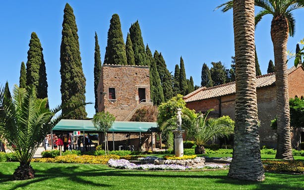 Entrance to Catacombs of St Callixtus with garden and stone building in Rome.